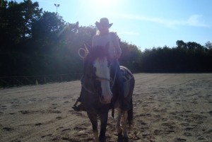 Rachel riding charlie with sunshine behind